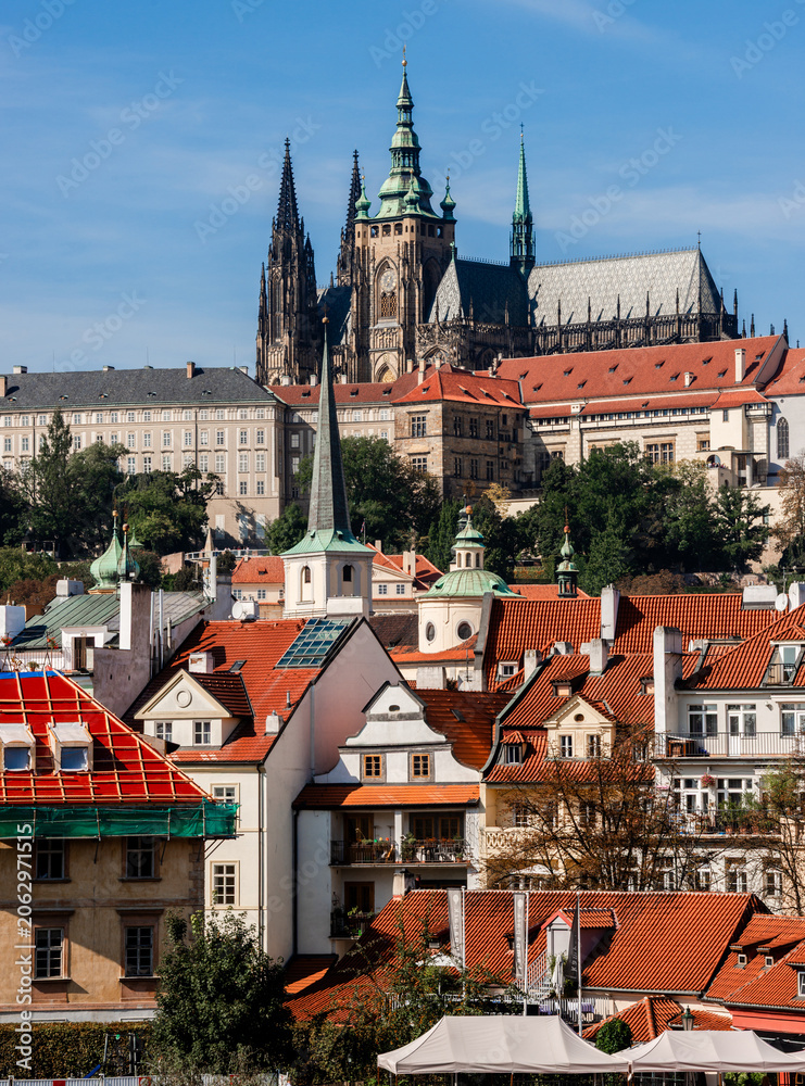 Obraz premium Prague Castle dominates city red roofs under bright sky