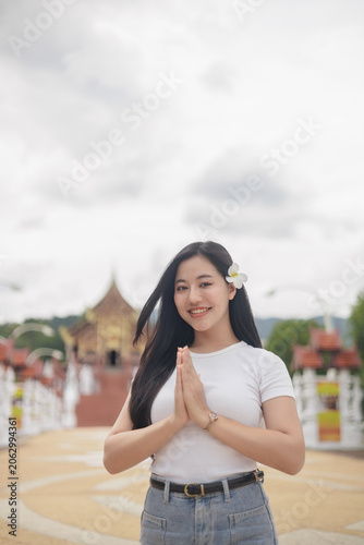 Foto Young Thai Woman Performing Traditional Wai Greeting at Buddhist Temple with Plu
