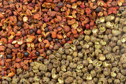 Red Sichuan peppercorns and green Chinese prickly ash divided into halves.