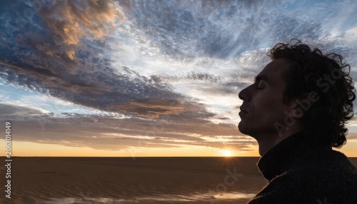 Mans Profile Gazing at Dramatic Sunset Sky Over Desert Landscape, Reflecting Calmness
