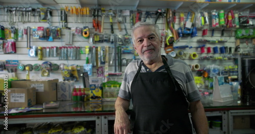 Bilde på lerret Experienced small business hardware store owner leaning on counter expressing tr