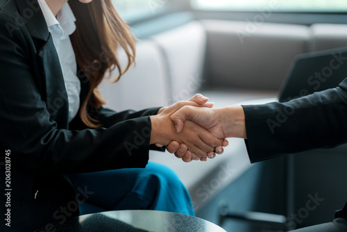 Two business colleagues shaking hands, closing a successful deal, agreement, or partnership. Collaboration and teamwork concept