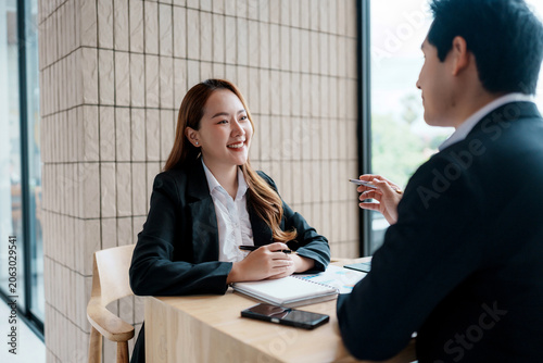 Asian businesswoman meeting employer, discussing career opportunities. Professional interaction between two business people hiring new talent