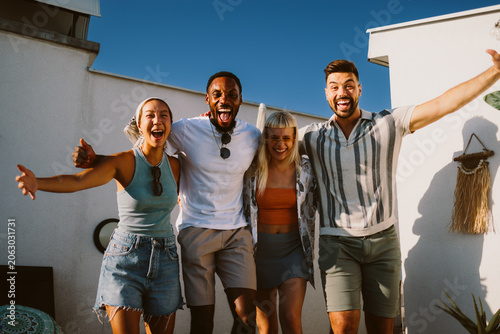 Diverse friends enjoying summer rooftop party together