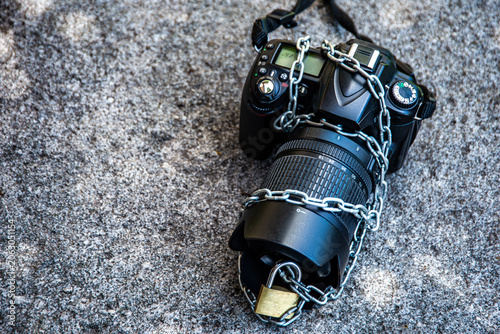 DSLR Camera Secured with Chain and Padlock on Concrete Surface | Photography Equipment Security