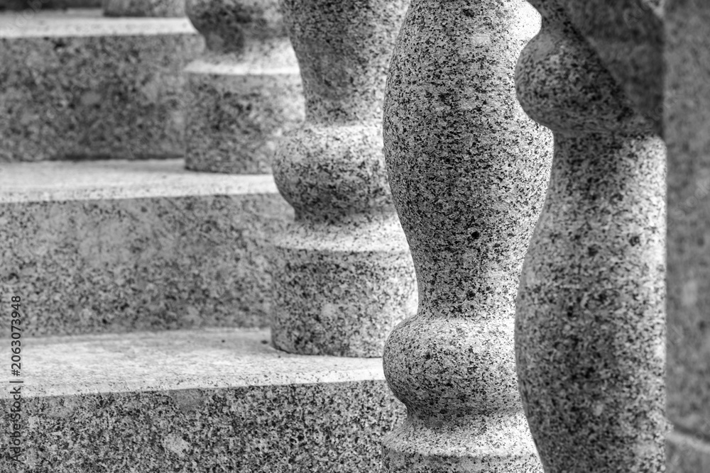 Naklejka premium Granite balusters and stone steps captured in monochrome, emphasizing architectural detail, texture, rhythm and symmetry. A timeless, durable abstract stairway composition