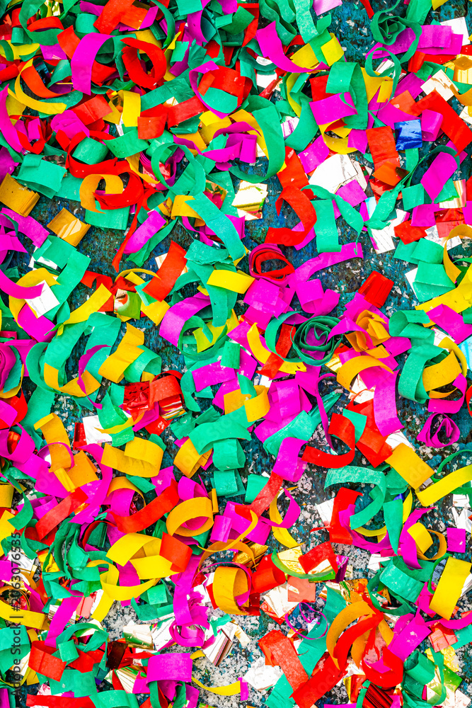 Naklejka premium Colorful streamers cover the ground during a festive celebration in a park on a sunny afternoon