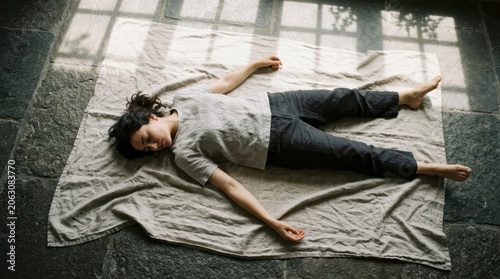 Woman Lying on Blanket in Natural Light Blanket Natural Light Serene Rest Relaxation Calm Indoor. Concept featuring blanket, natural light, serene, rest, relaxation for professional commercial design.