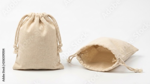 Two small beige cotton fabric drawstring pouches for storage presented nicely on white background