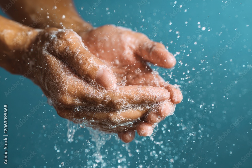 Fototapeta premium Two Hands Holding Soapy Foam Under Running Water In Blue Light bubbles