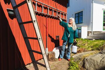 Senior Woman watering Green Sedum Roof