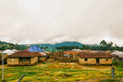 Scenic Rural Landscape of Mbeya Town, Tanzania with Houses and Lush Green Hills Under a Cloudy Sky