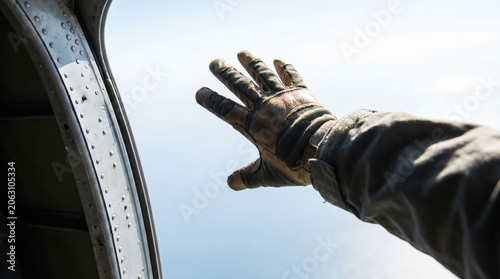 Skydiving hand glove aircraft door open sky view captures adventure training moment before freefall above distant earth