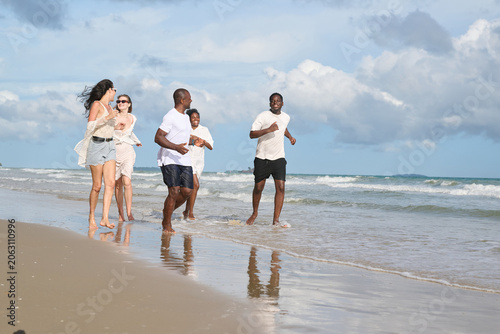 Cuadro en lienzo Group of friends joyfully running along the beach