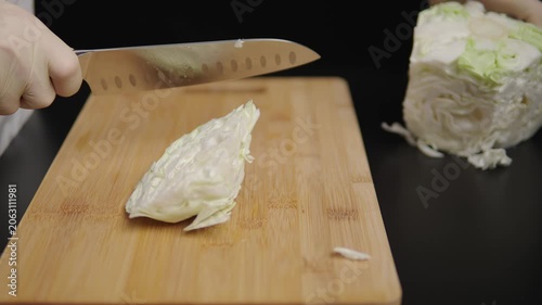 Hand shredding cabbage on a cutting board