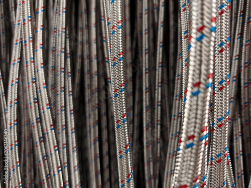 Photos Metal braided water supply hoses presented on hanging hooks in building material