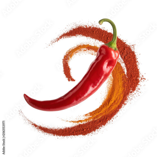 A fresh red chili pepper positioned in the center with a swirling trail of red and orange spice powder isolated on a dark