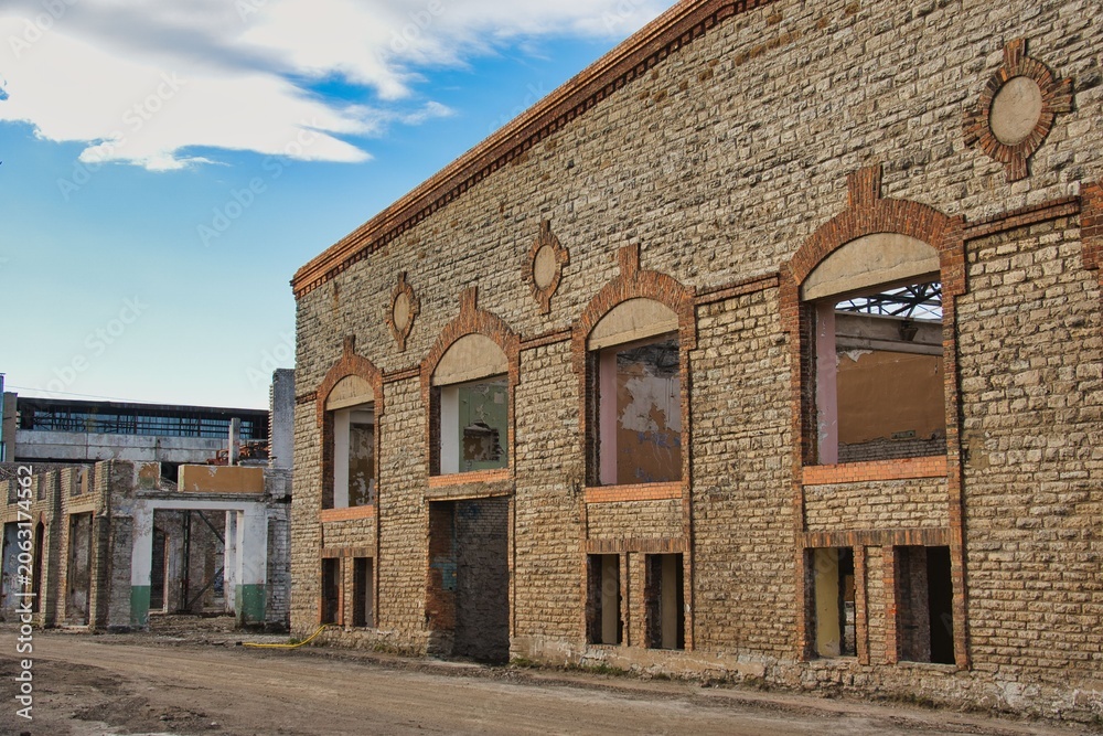 Obraz premium Old Abandoned Factory Building with Limestone and Brick Facade