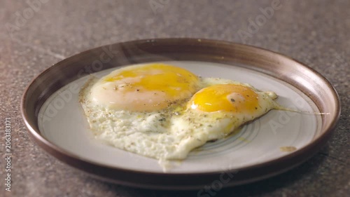 hot and steaming fried eggs on a plate for breakfast