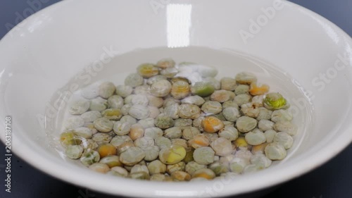A white bowl filled with green peas and carrots, perfect for salads or side dishes