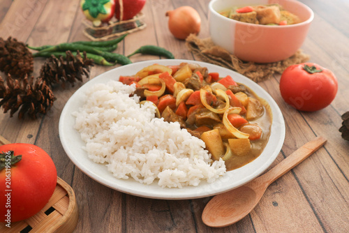 Valokuva A plate of hearty Japanese curry with diced chicken, carrot, onion, and potatoes, served with white rice