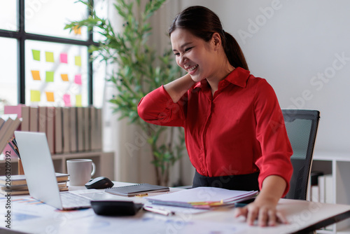 Konstfotografi Asian businesswoman suffering from neck pain and shoulder stiffness, rubbing her