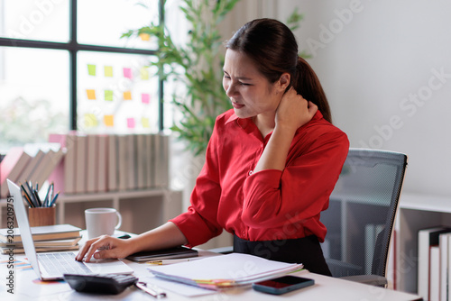 Obraz na płótnie Woman experiencing neck and shoulder pain from long hours at the computer, massa