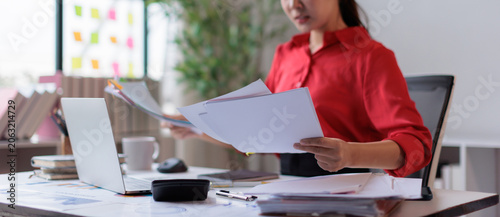 Obraz na plátně Professional woman managing business documents, working and reviewing papers on