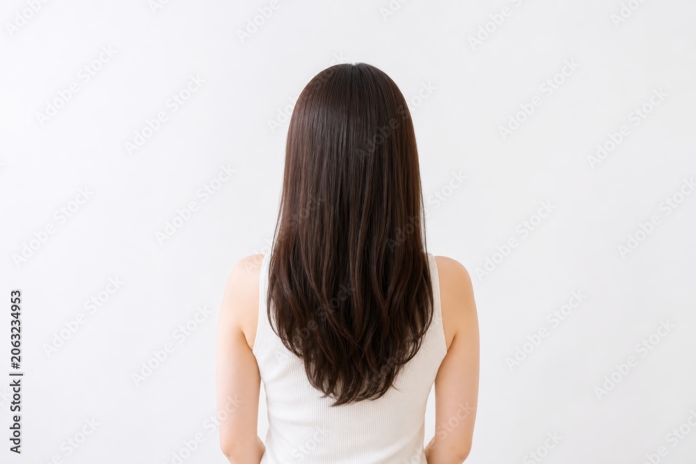 Obraz premium 明るい部屋で後ろ髪を見せる女性の朝のヘアケア