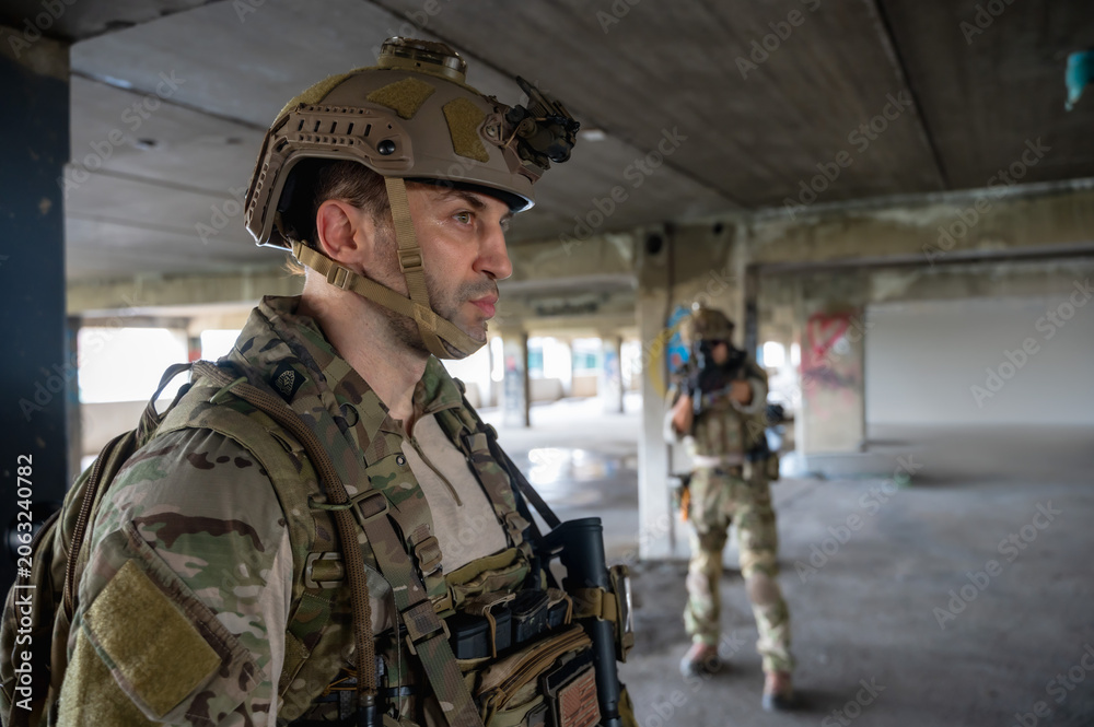 Fototapeta premium Special armed military squad team in full gear patrolling an abandoned building during hostage mission