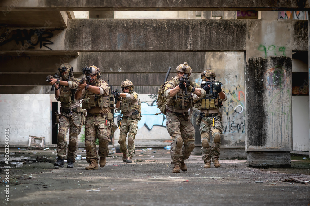 Fototapeta premium Special armed military squad team in full gear patrolling an abandoned building during hostage crisis