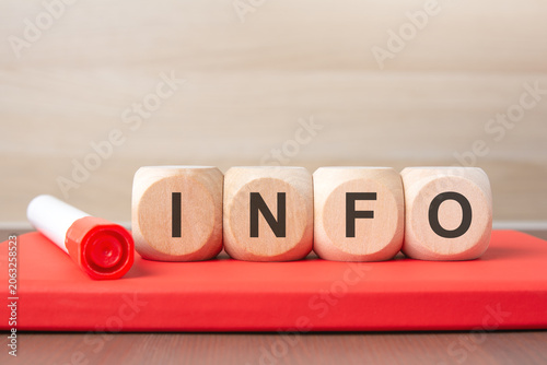 Wooden cubes with INFO text on a red notebook.