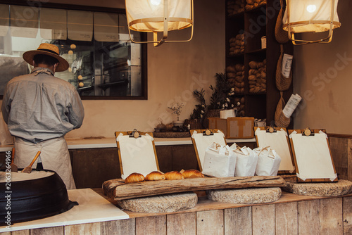 Photography Artisan Korean bakery interior with baker in straw hat, fresh salt bread and empty clipboards for copy space