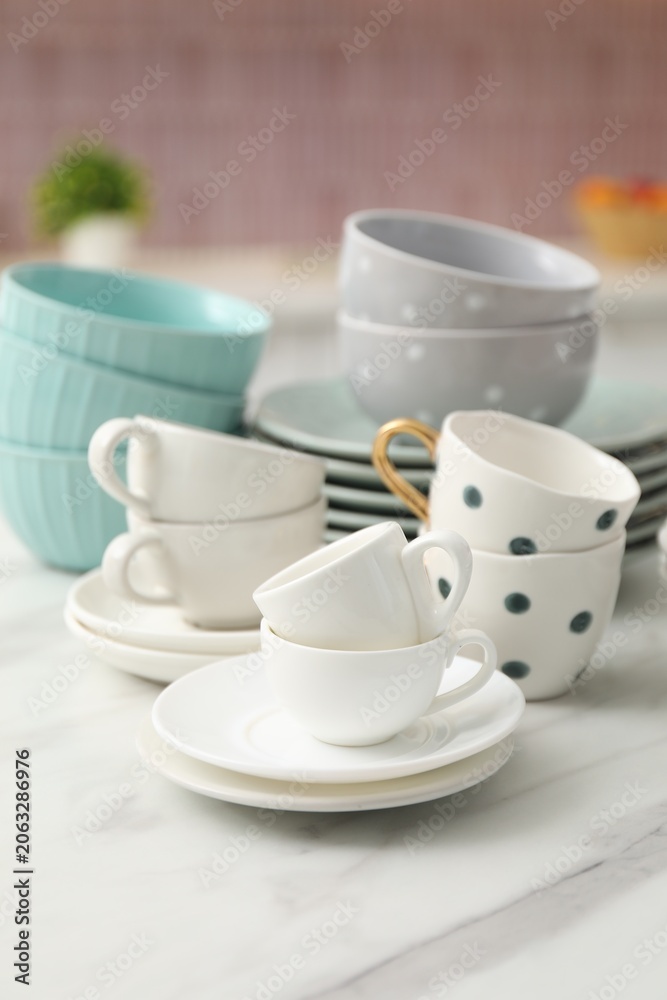 Fototapeta premium Different clean dishware on white table in kitchen, closeup