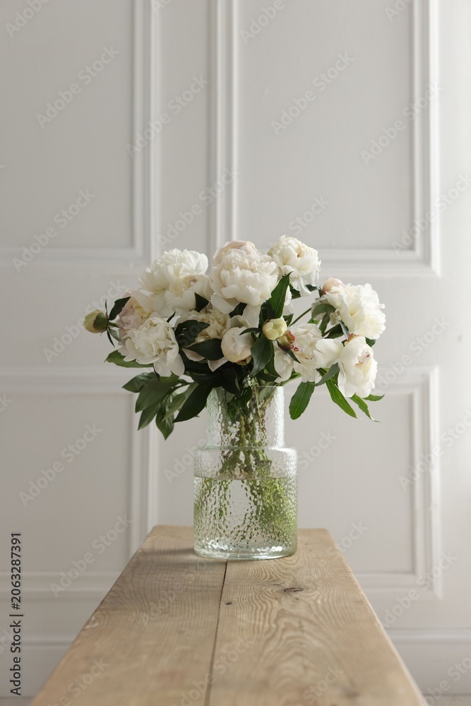 Fototapeta premium Bouquet of beautiful peony flowers on wooden bench indoors