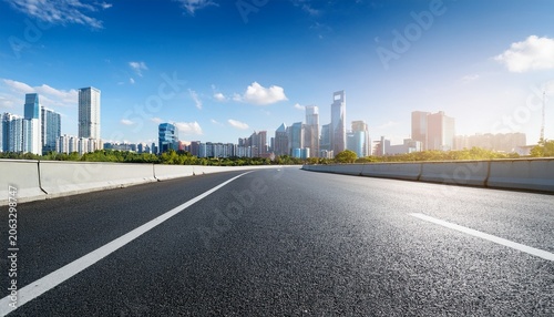 empty asphalt highway road and city skyline with residential area buildings under blue sky