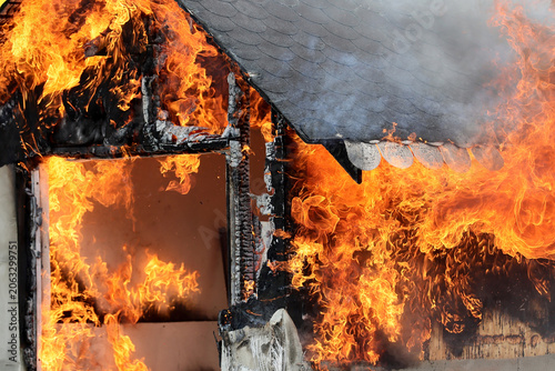 Fotografi A miniature house burns in a controlled manner to observe the behavior of different materials and untreated wood against fires