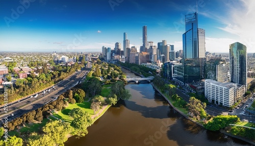drone vertical shot of the melbourne cityscape with a river and green trees on a sunny day