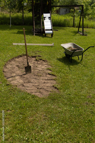 Gardening project in backyard with shovel and wheelbarrow during spring