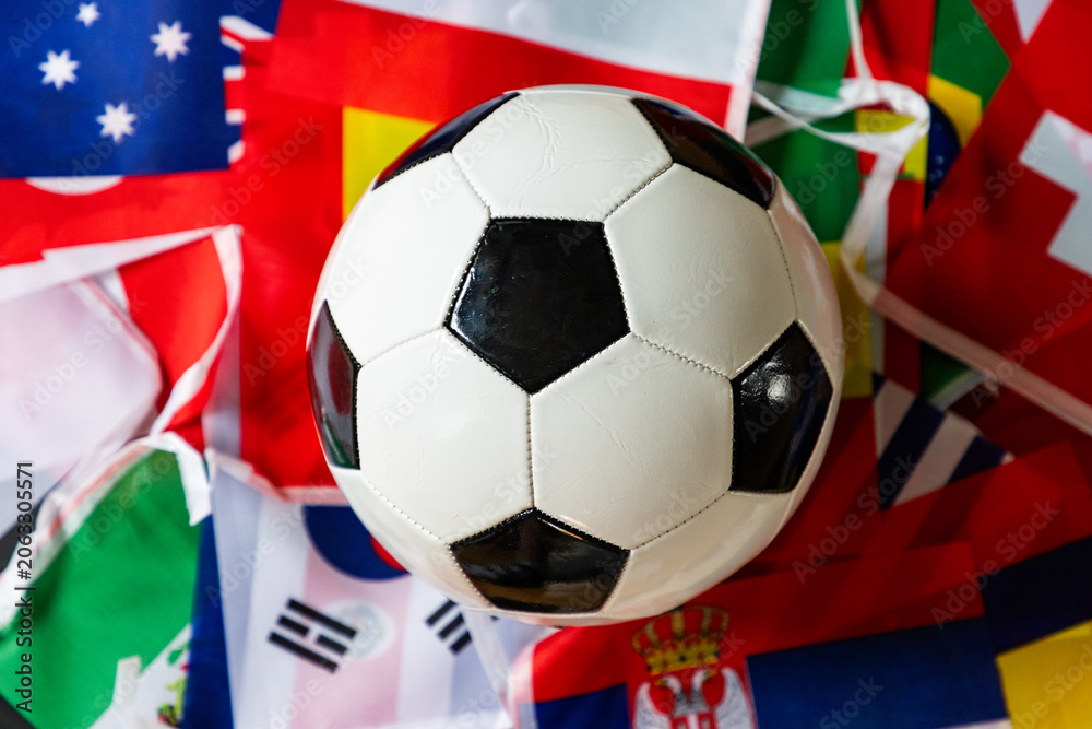 Fototapeta premium classic black and white soccer ball on world flags