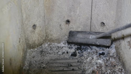 Cleaning ashes from a fireplace in a living room during the afternoon