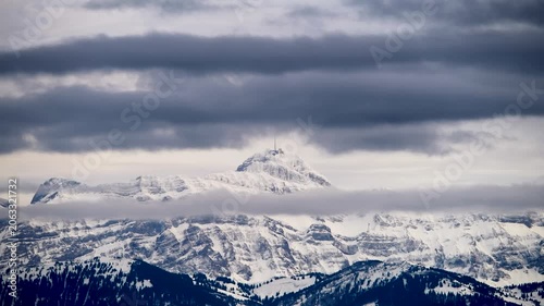 Snowy mountain peaks under a cloudy sky at dusk in the winter season