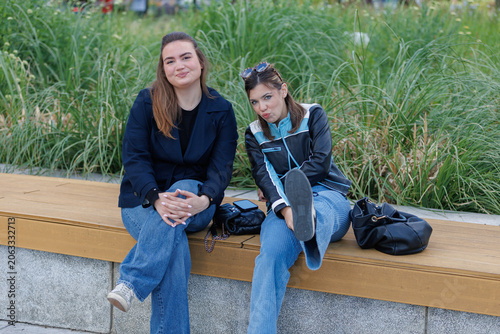 two Gen Z girls sitting on the bench