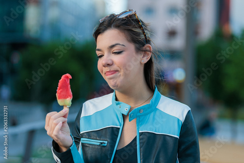 young woman having a melting ice cream in the city
