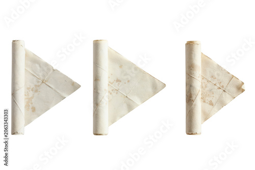 Three triangular shapes made from rolled aged parchment paper, arranged in a row to resemble a play button isolated on a black background