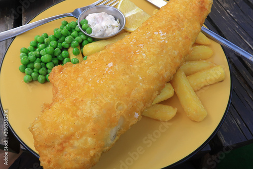 A plate of Fish and Chips with peas and tartare sauce