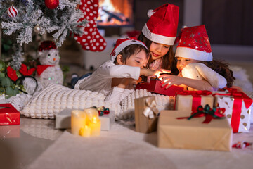Happy children play with soft fake snow by a window during a festive Christmas morning celebration indoors at home together.