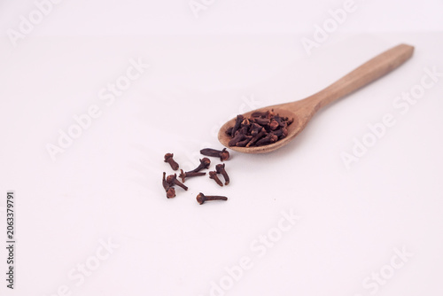 Fotografie Wooden spoon holds dried cloves
