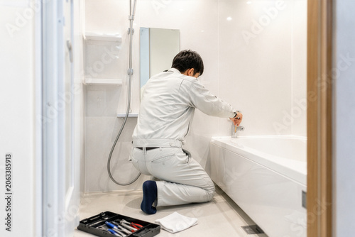 浴室の水栓を修理する作業員
