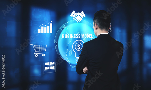 Business Professional Analyzing Global Business Models and Data Visualizations in a Modern Office Environment Quark.